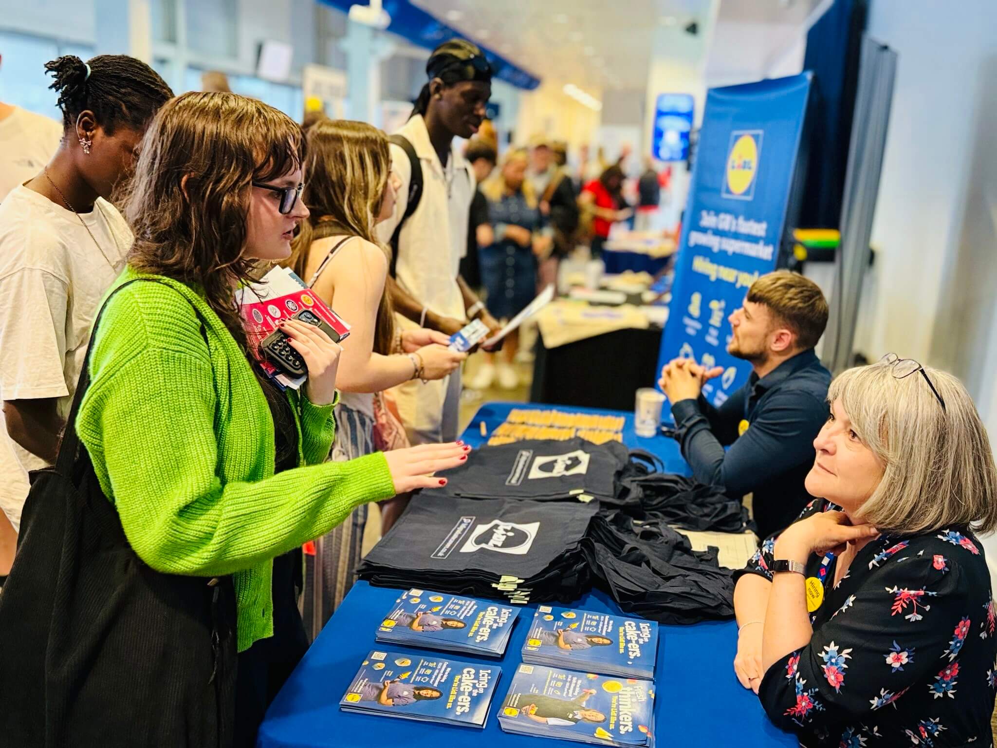 A candidate talking to an exhibitor at a Job Fair