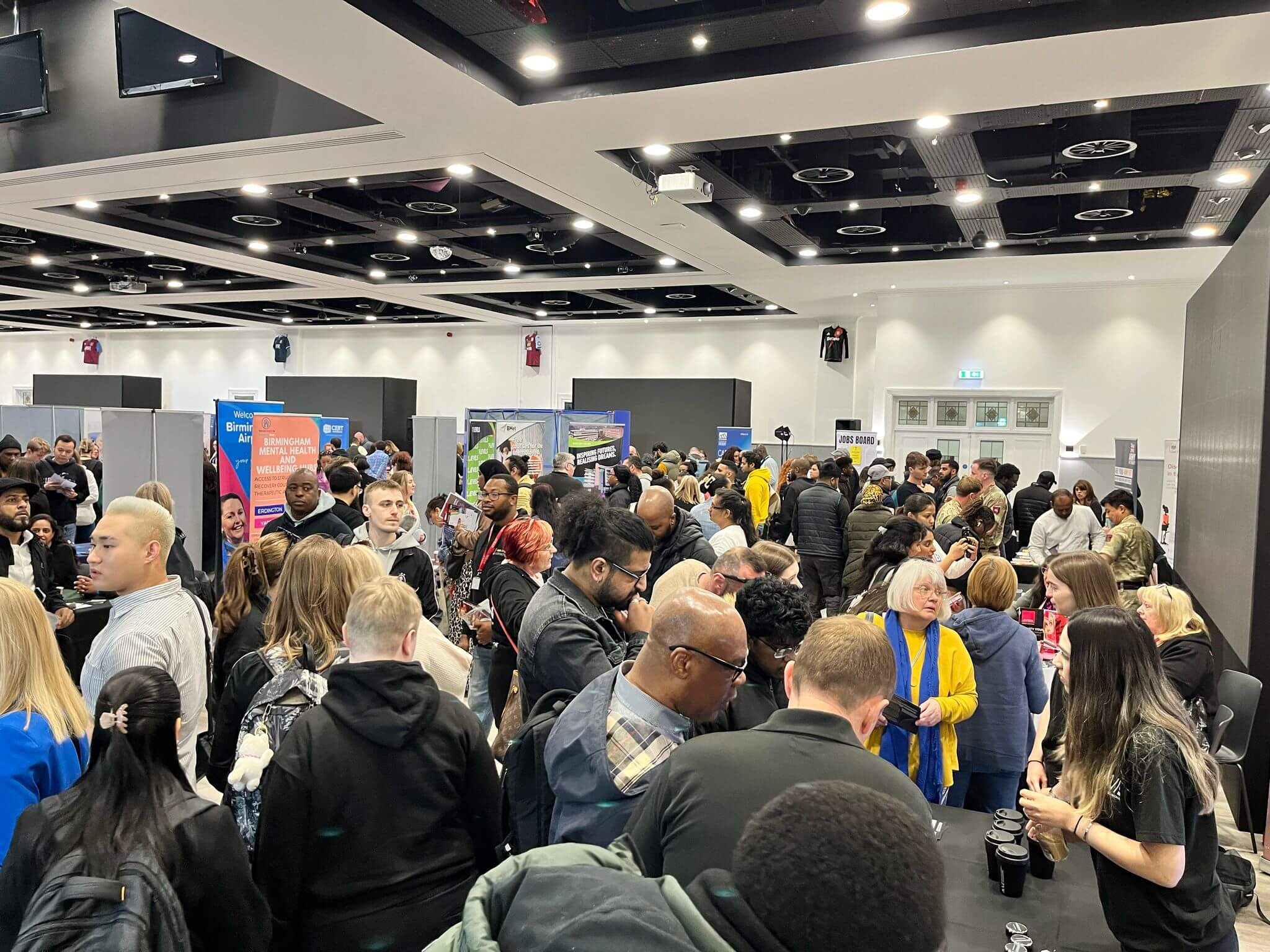 Candidates browsing exhibitor stands at a busy Job Fair