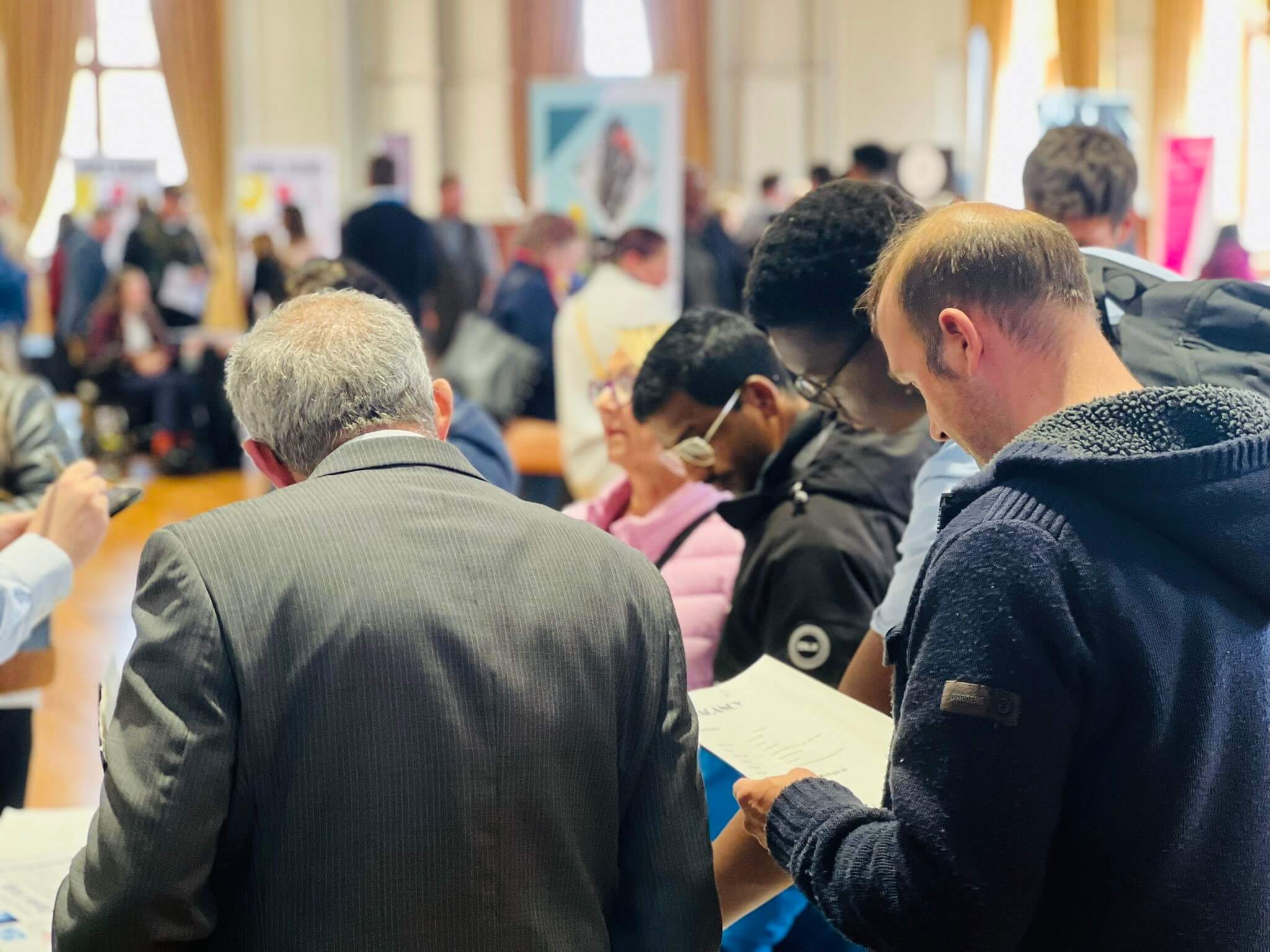 Candidates speaking with exhibitors at a Job Fair