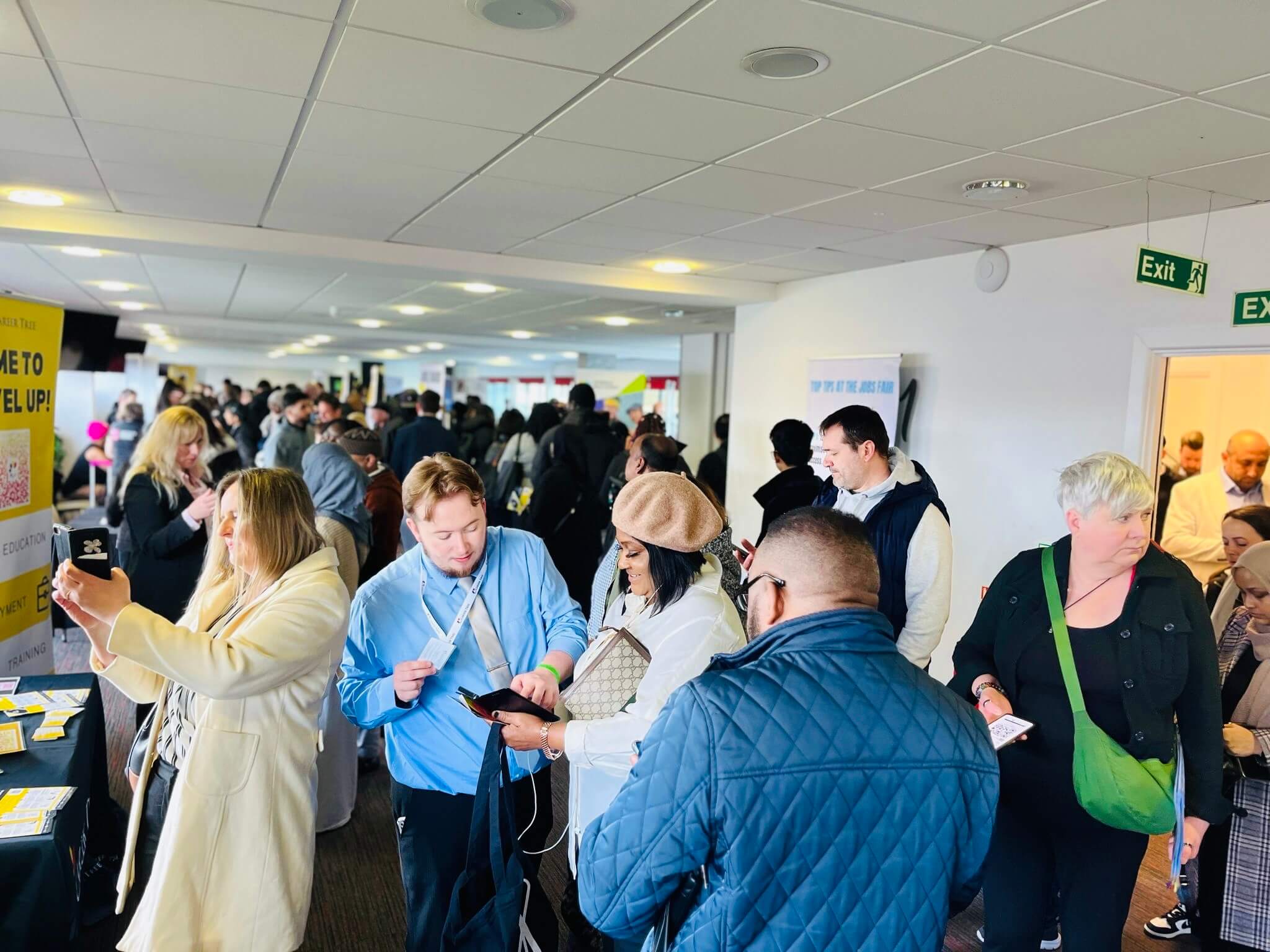 A busy Job Fair with candidates speaking to exhibitors